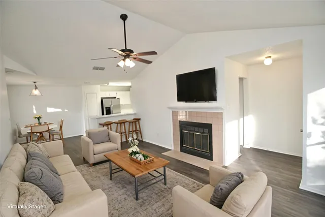 a living room with furniture a fireplace and a flat screen tv