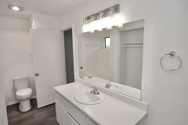 a bathroom with a granite countertop sink a toilet and a mirror