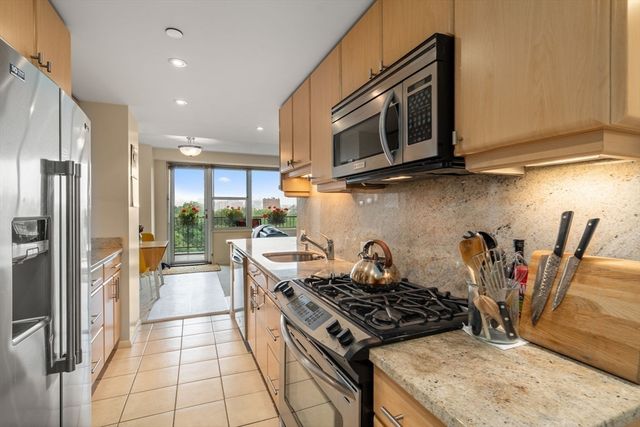 a kitchen with stainless steel appliances granite countertop a stove a microwave and a refrigerator
