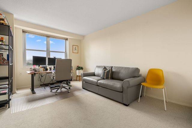a living room with furniture a flat screen tv and a window