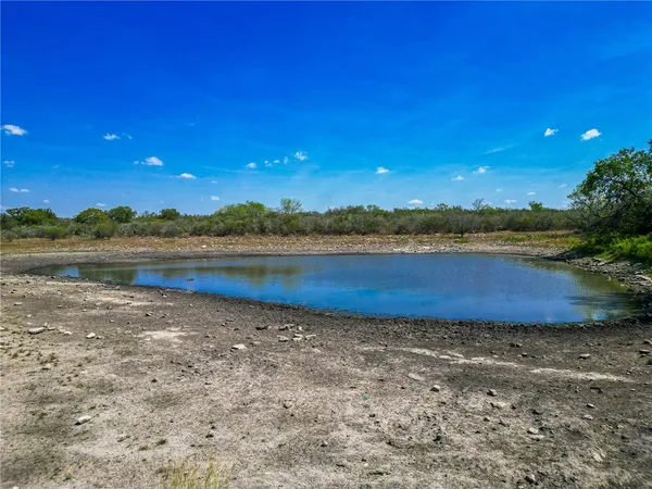 a view of a lake with sunset in background