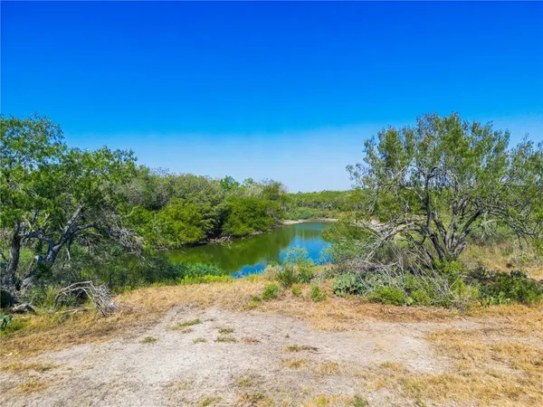 a view of a lake with beach and green space