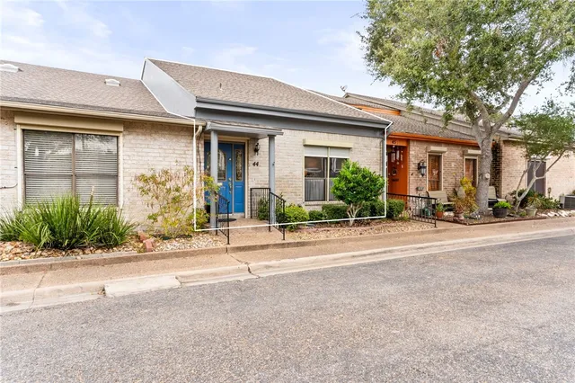 front view of a brick house with potted plants