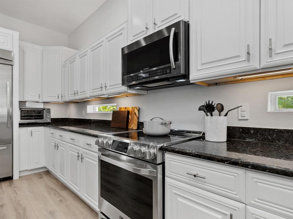 2159 Hawthorne Street Sarasota, FL 34239 - Photo 13 of 47 a kitchen with granite countertop white cabinets stainless steel appliances and sink