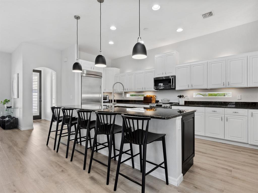 2159 Hawthorne Street Sarasota, FL 34239 - Photo 10 of 47 a kitchen with stainless steel appliances granite countertop a stove top oven a sink a refrigerator and chairs
