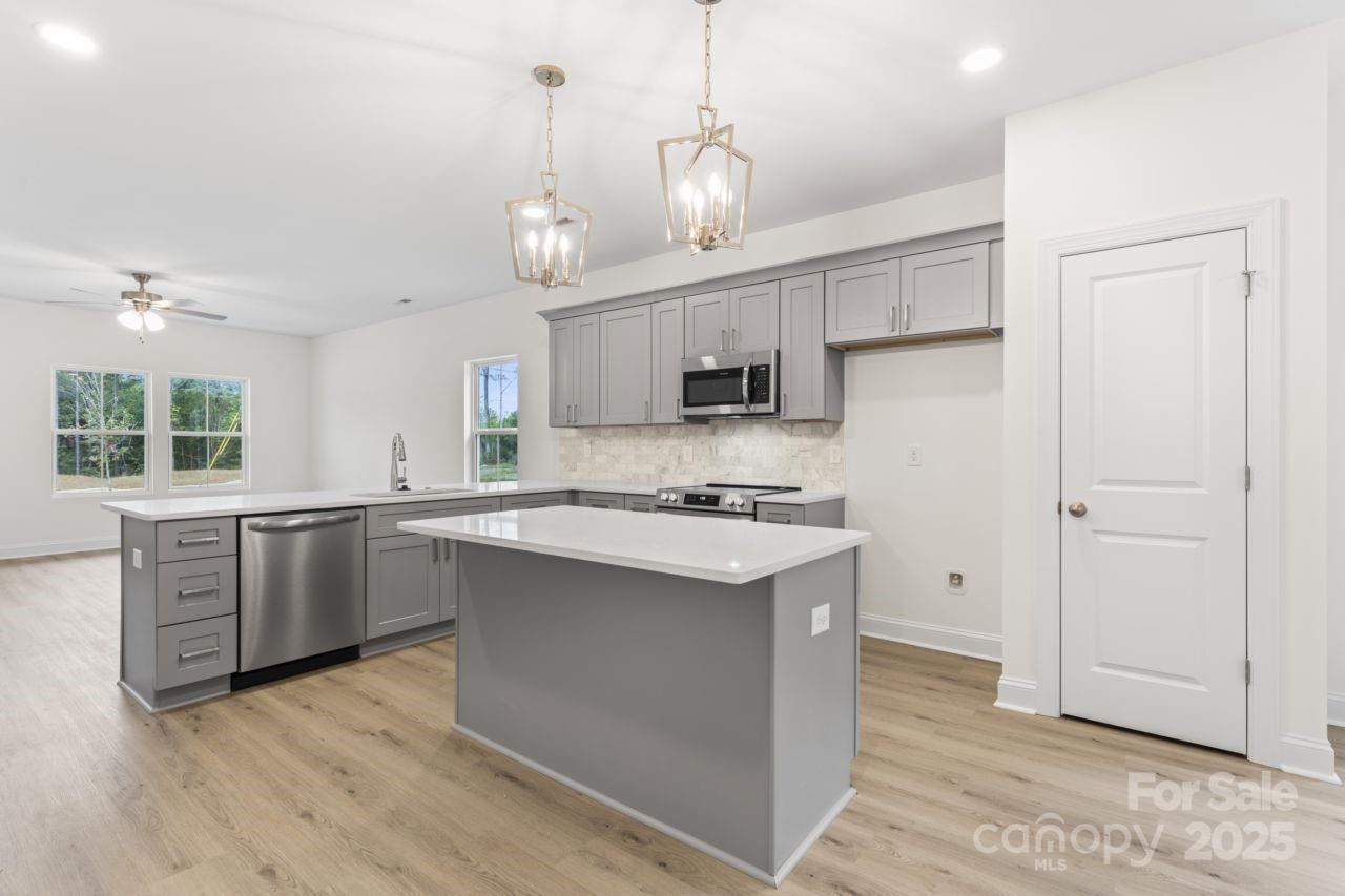 751 Mockingbird Road, Unit 1 Albemarle, NC 28001 - Photo 13 of 29 a kitchen with stainless steel appliances granite countertop a sink a stove a refrigerator and island with wooden floor