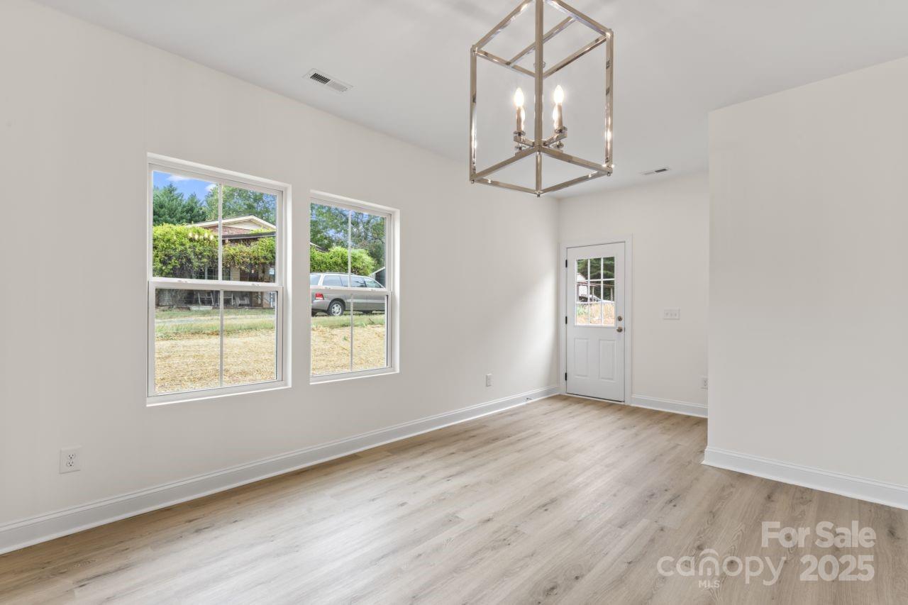 751 Mockingbird Road, Unit 1 Albemarle, NC 28001 - Photo 18 of 29 an empty room with wooden floor exposed radiator and windows