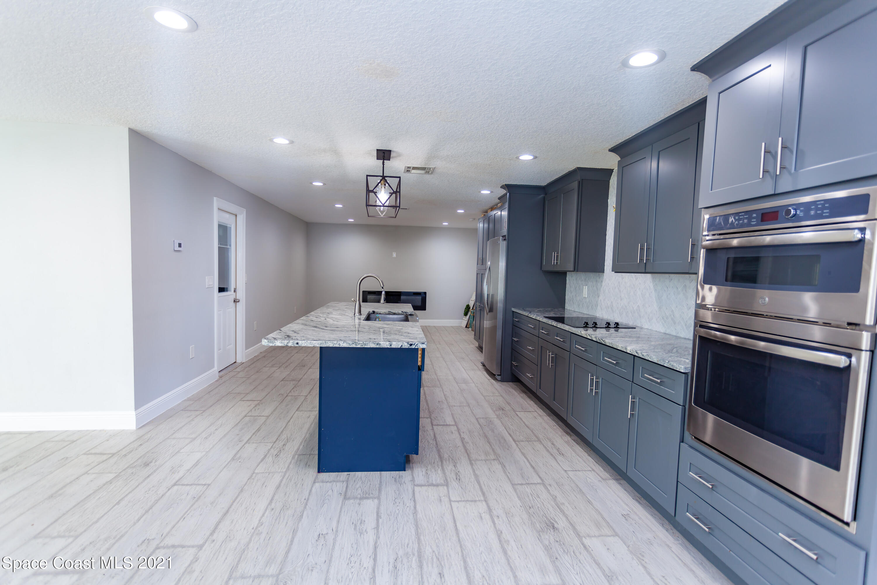 3400 Harlock Road Melbourne, FL 32934 - Photo 14 of 28 a kitchen with stainless steel appliances kitchen island granite countertop a stove a refrigerator and a wooden floors