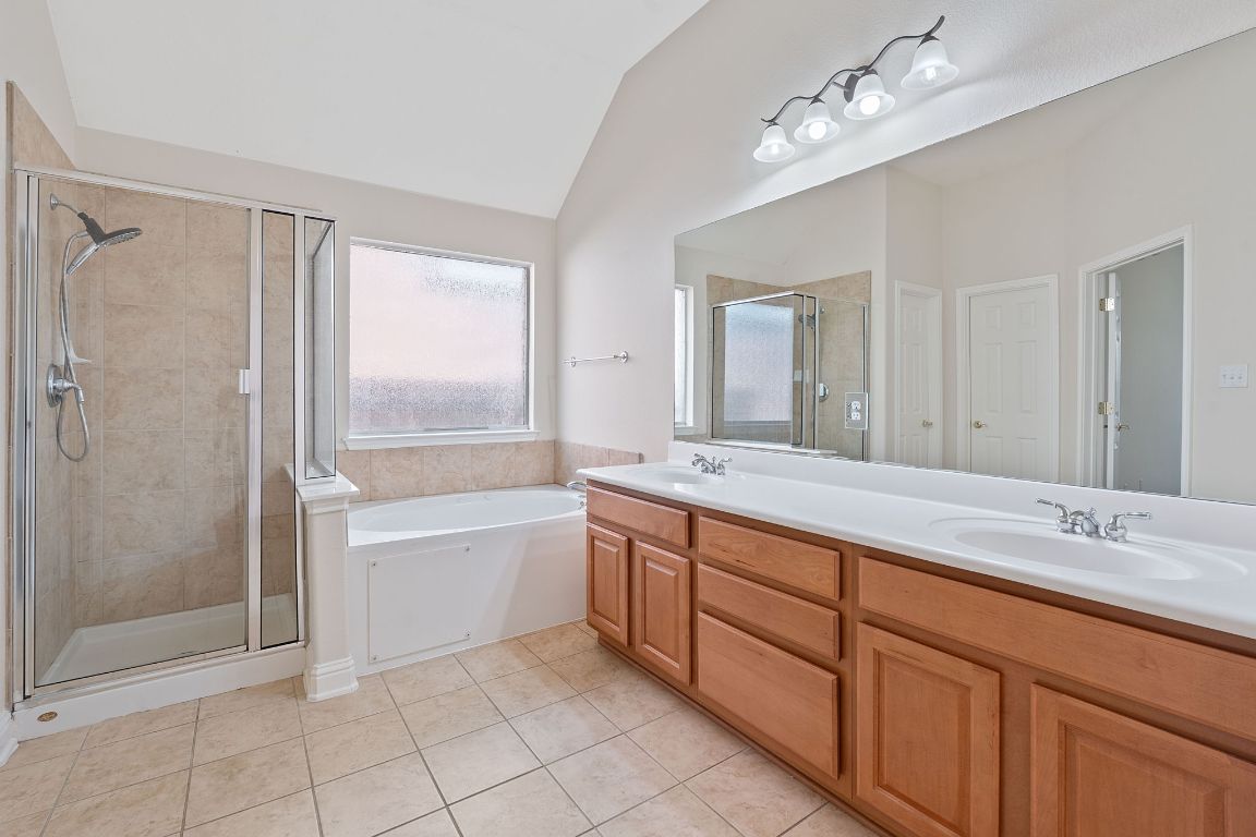 738 Nelson Ranch Road Cedar Park, TX 78613 - Photo 22 of 35 Full bathroom with tile patterned flooring, a sink, vaulted ceiling, and a shower stall