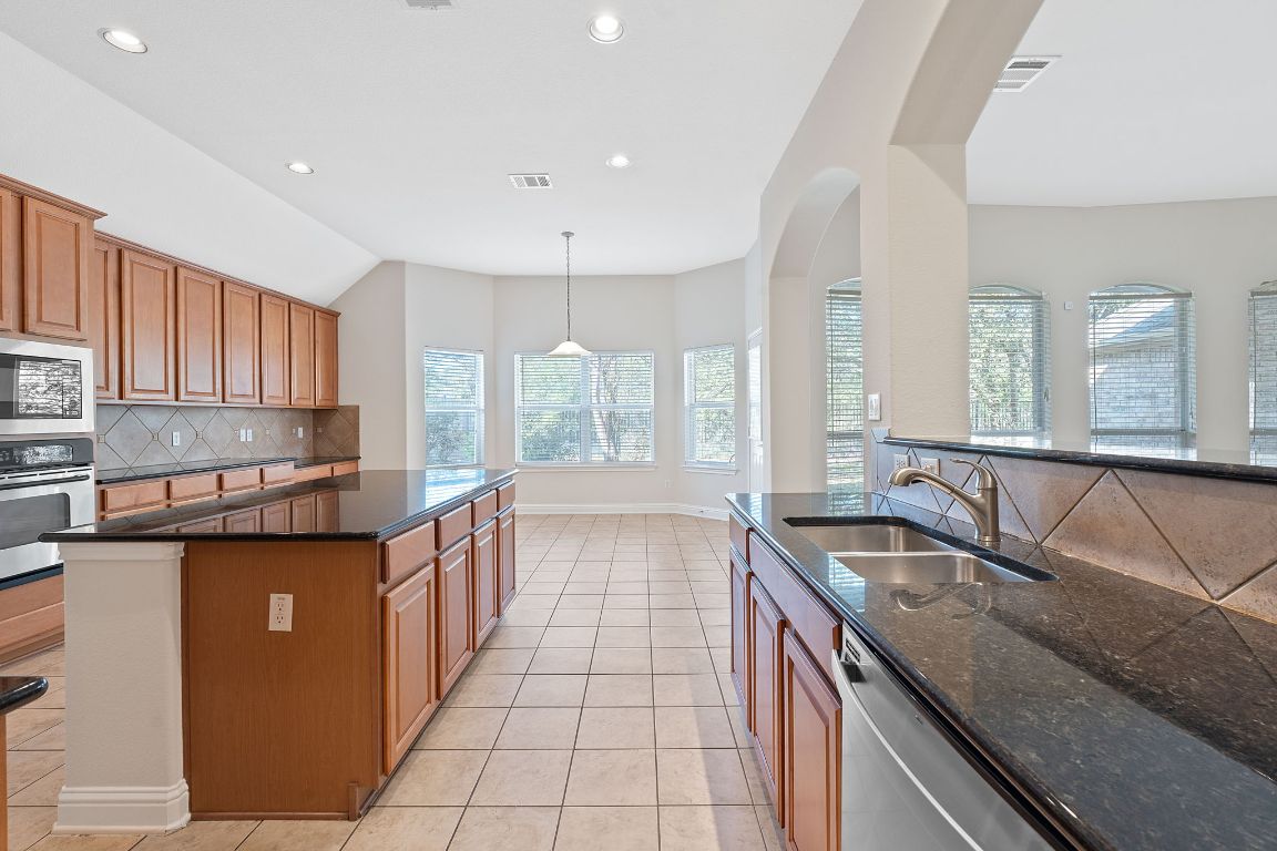 738 Nelson Ranch Road Cedar Park, TX 78613 - Photo 7 of 35 Kitchen featuring a sink, appliances with stainless steel finishes, light tile patterned floors, visible vents, and decorative backsplash