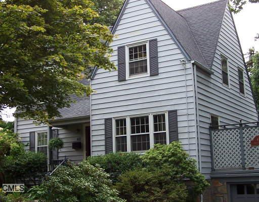 a view of a house with a yard and potted plants