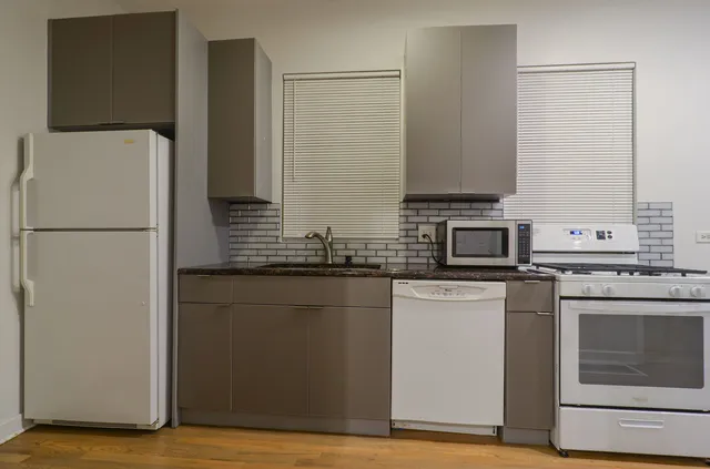 a kitchen with stainless steel appliances granite countertop a refrigerator a stove a sink and a microwave