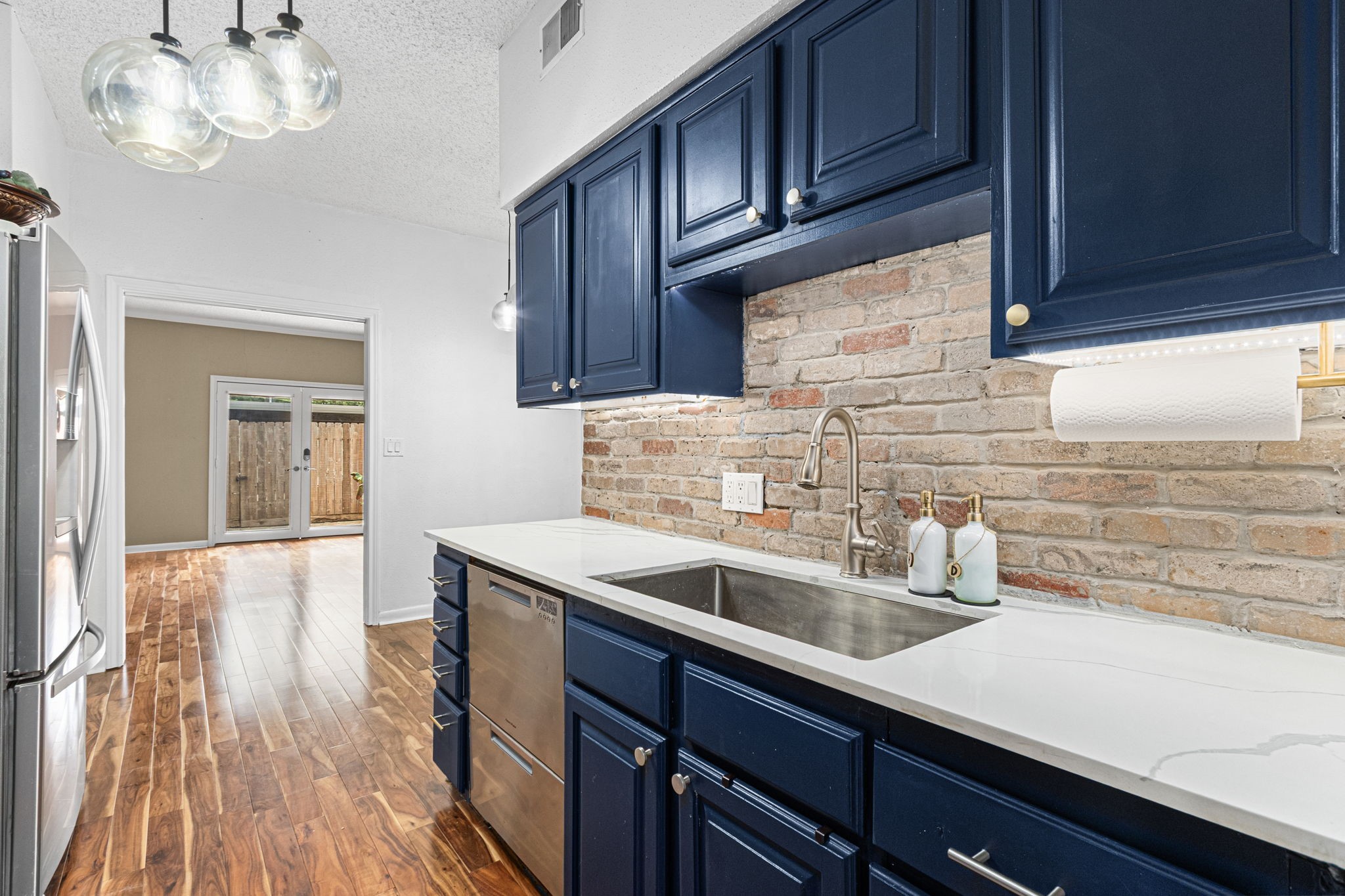 3749 Wakeforest Avenue Houston, TX 77098 - Photo 15 of 36 Quartz countertops adorn blue cabinetry.
