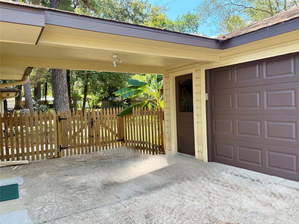 1111 Burning Tree Road Kingwood, TX 77339 - Photo 30 of 32 Spacious two-car garage with a covered walkway and charming picket fence leading to the backyard.
