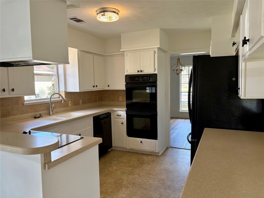 1111 Burning Tree Road Kingwood, TX 77339 - Photo 8 of 32 Modern kitchen with abundant natural light, sleek black appliances, and ample counter space. Perfect for culinary enthusiasts!