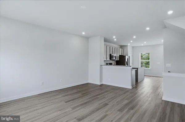 a kitchen with stainless steel appliances a stove top oven a sink a refrigerator and a granite counter tops