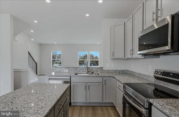 a view of a kitchen with wooden floor and electronic appliances