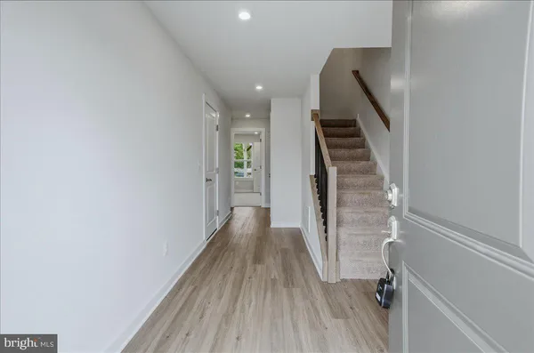 a view of a hallway with wooden floor and staircase