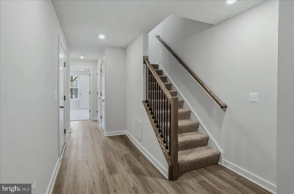 a view of a hallway with wooden floor and entryway