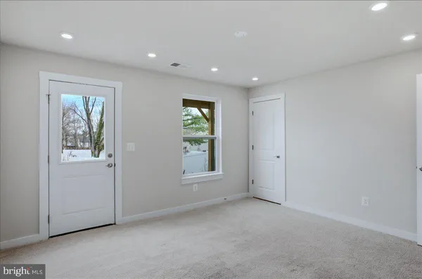 an empty room with windows and closet