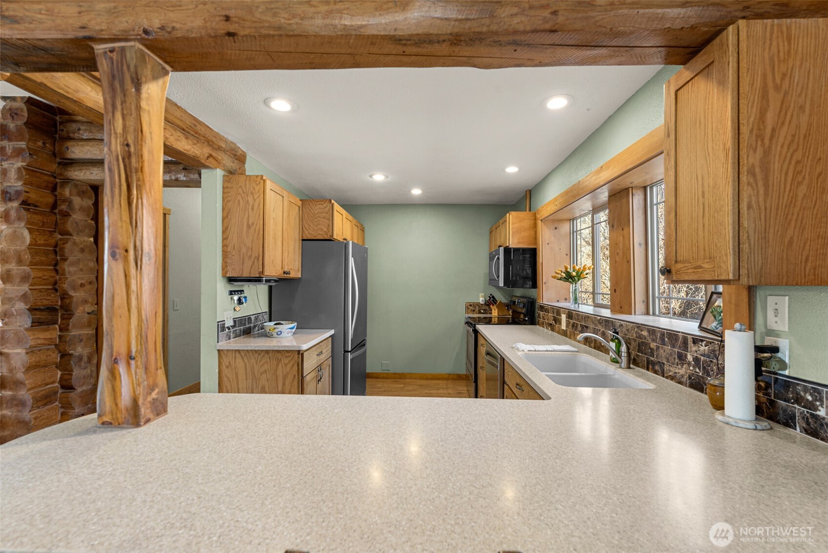 75 Purtteman Gulch Road Chelan, WA 98816 - Photo 9 of 40 a large kitchen with stainless steel appliances a large counter top a stove and a refrigerator