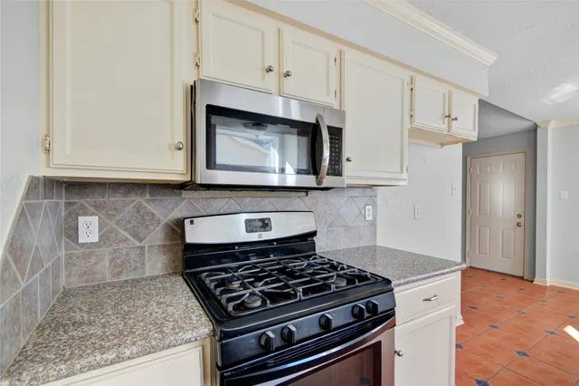 a stove top oven sitting inside of a kitchen