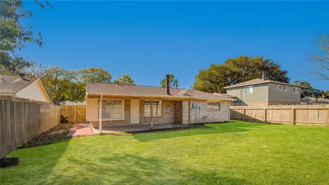 a view of a house with a big yard potted plants and large tree