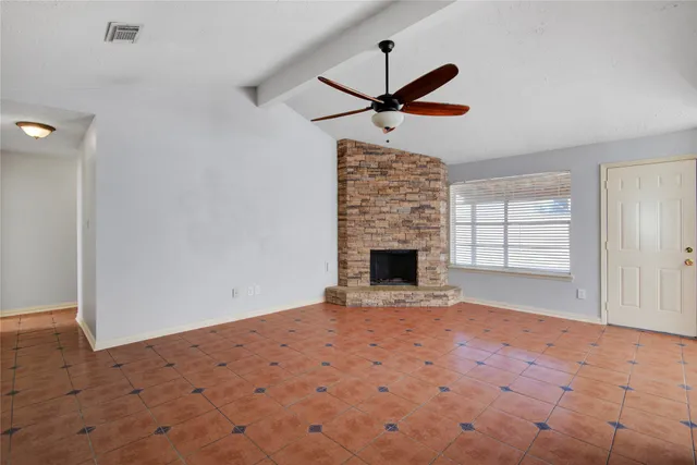 a view of empty room with wooden floor and fireplace
