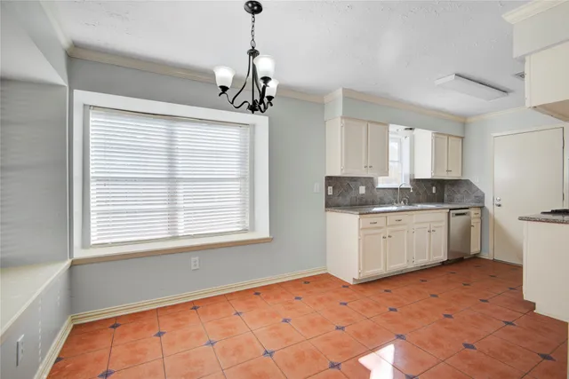 a kitchen with granite countertop a sink cabinets stainless steel appliances and a window