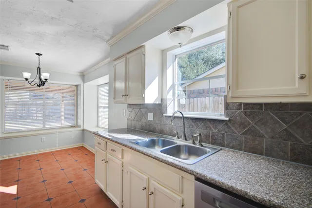 a kitchen with a sink a window and cabinets