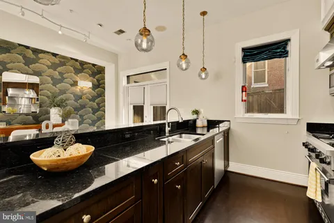 a view of a bathroom with a sink and mirror with wooden floor