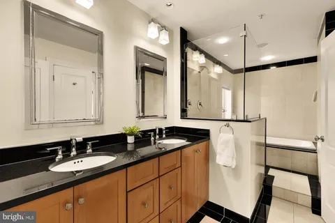 a bathroom with a double vanity sink a mirror and a shower