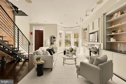 a living room with furniture fireplace and a large window