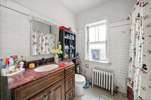 a bathroom with a sink toilet and a window