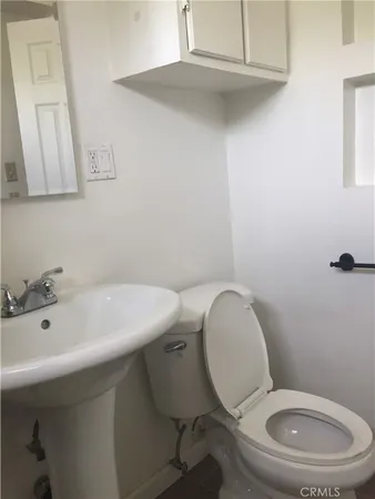 a bathroom with a toilet a sink and mirror