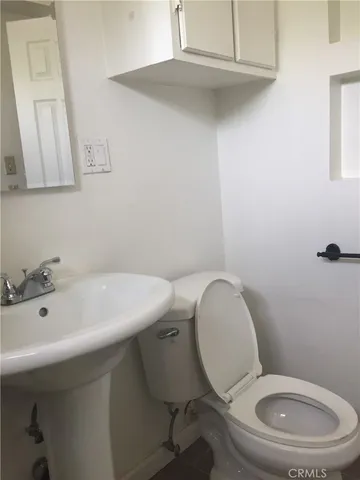 a bathroom with a toilet a sink and mirror