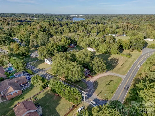 an aerial view of a residential houses with outdoor space and trees