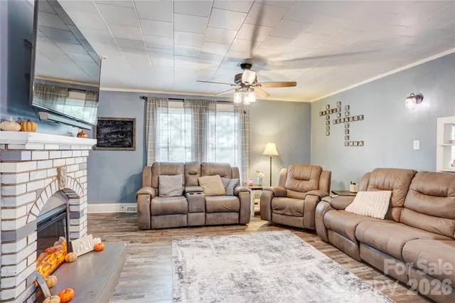 a living room with furniture a fireplace and a flat screen tv