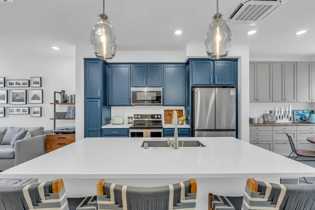 a kitchen with stainless steel appliances a table chairs and a refrigerator