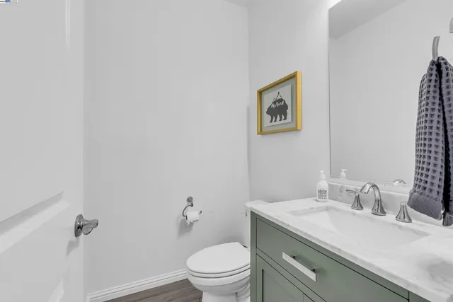 a bathroom with a granite countertop sink mirror vanity and toilet