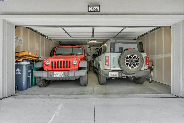 a utility room with stainless steel appliances and lots of white furniture