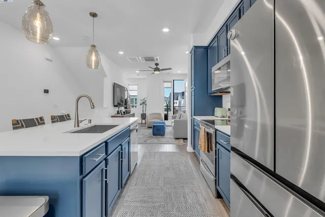 a kitchen with stainless steel appliances granite countertop a sink a refrigerator and a stove