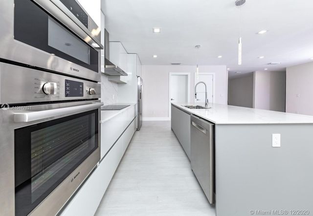 a large kitchen with a stove and a sink