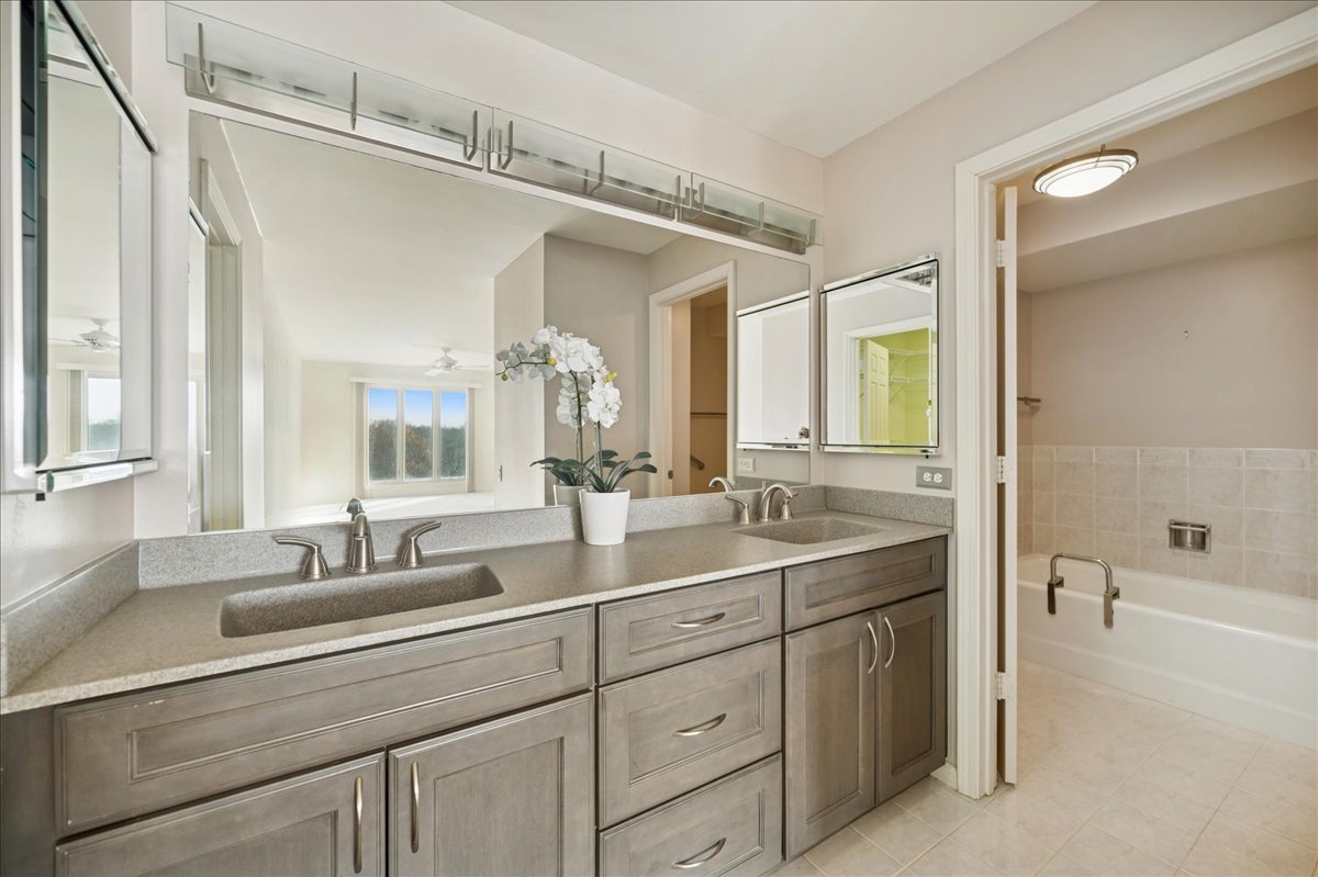 1721 Mission Hills Road, Unit 406 Northbrook, IL 60062 - Photo 17 of 23 a bathroom with a double vanity sink mirror and bathtub
