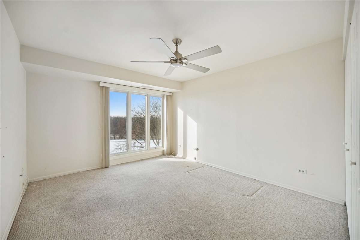 1721 Mission Hills Road, Unit 406 Northbrook, IL 60062 - Photo 19 of 23 an empty room with windows and fan