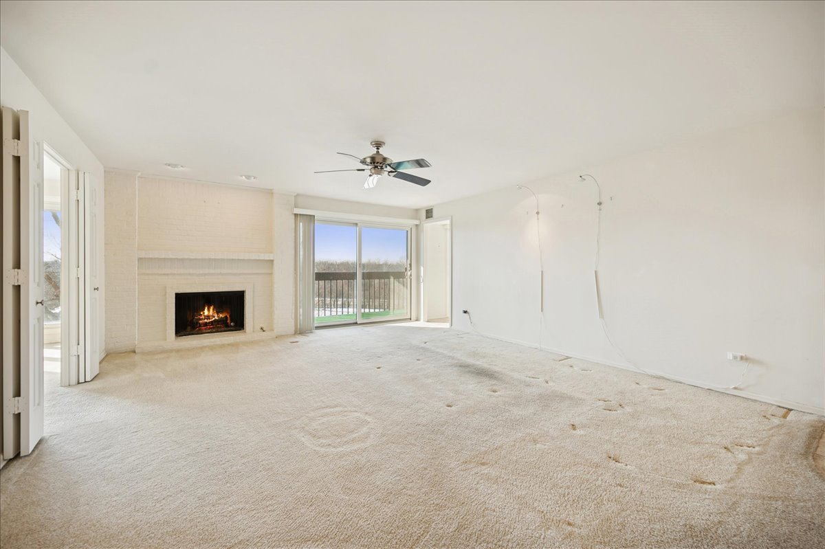 1721 Mission Hills Road, Unit 406 Northbrook, IL 60062 - Photo 4 of 23 a view of an empty room with a fireplace