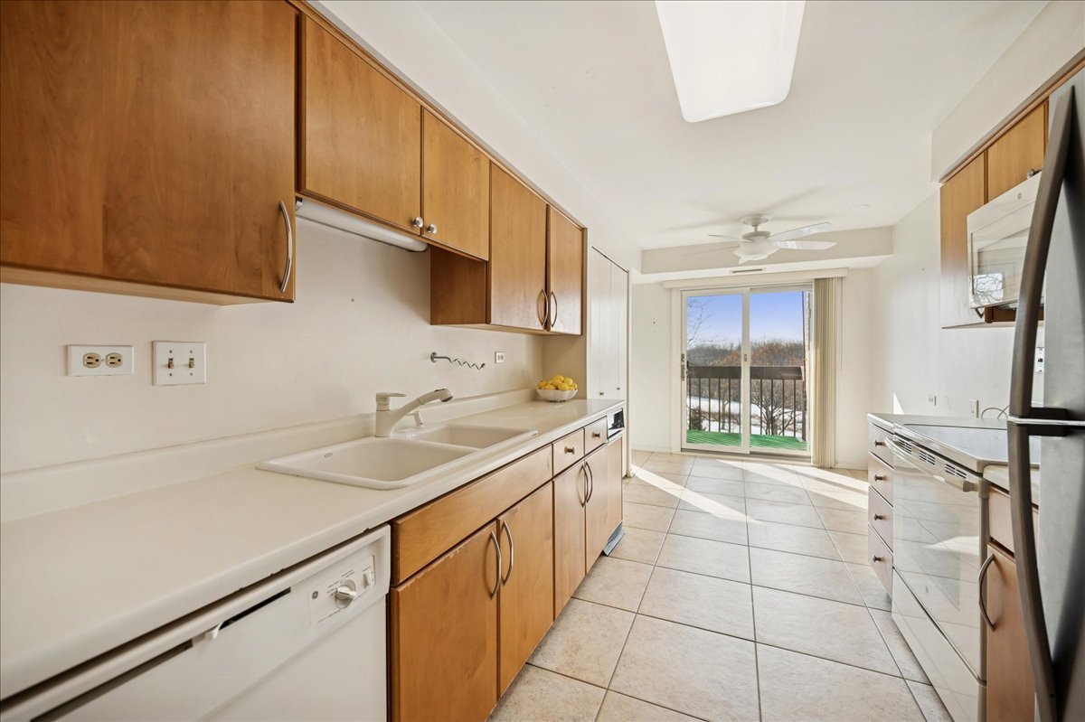 1721 Mission Hills Road, Unit 406 Northbrook, IL 60062 - Photo 9 of 23 a kitchen with a sink a stove and a refrigerator