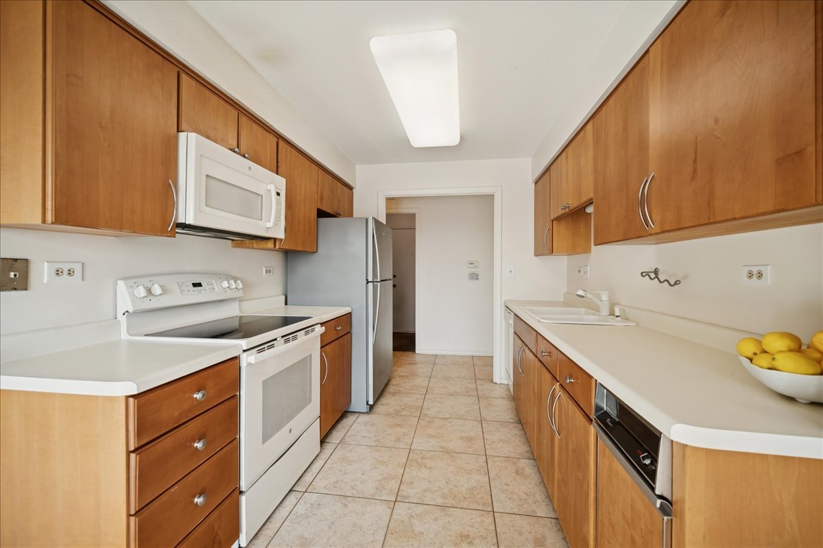 1721 Mission Hills Road, Unit 406 Northbrook, IL 60062 - Photo 10 of 23 a kitchen with stainless steel appliances a stove a sink and a microwave