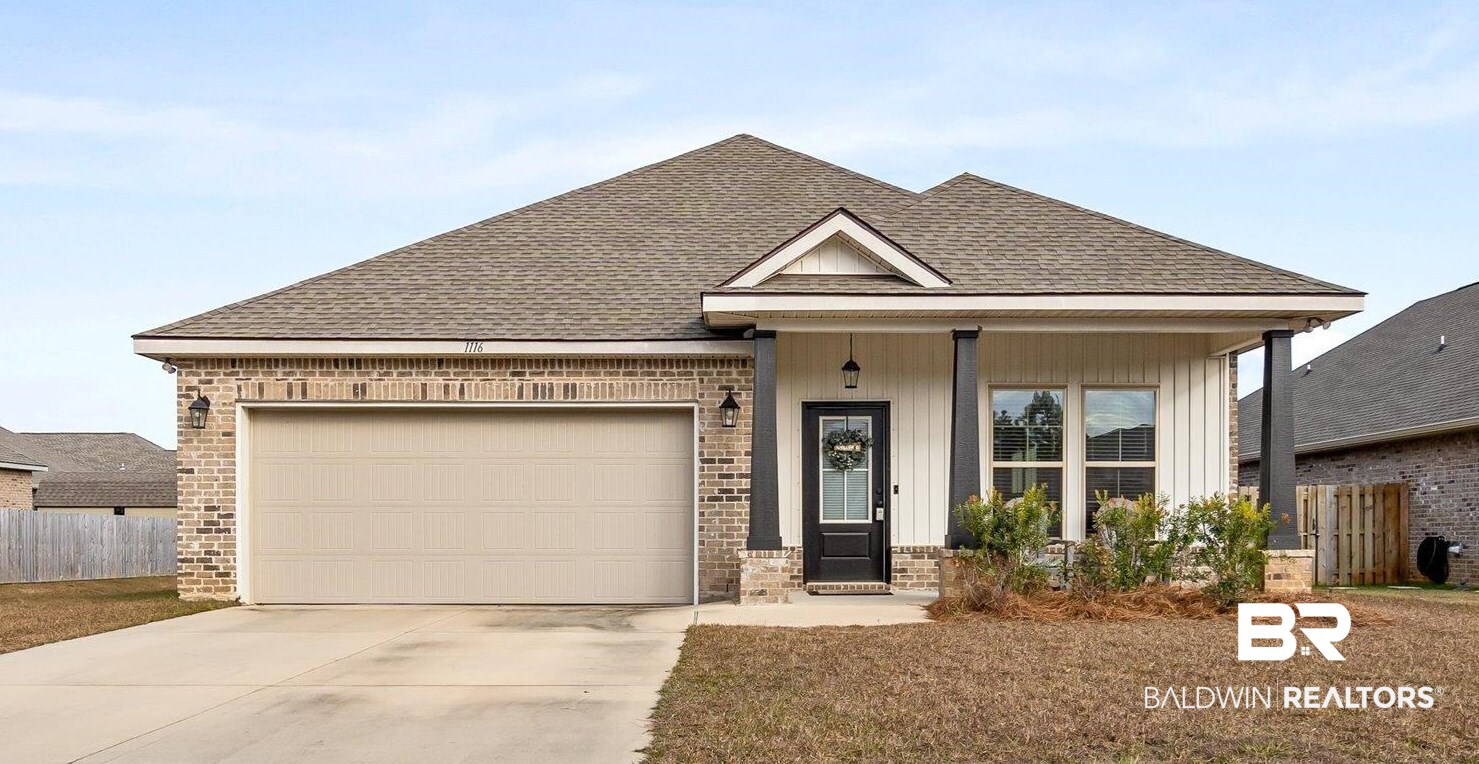 View of front facade featuring a garage, a porch, and a front lawn