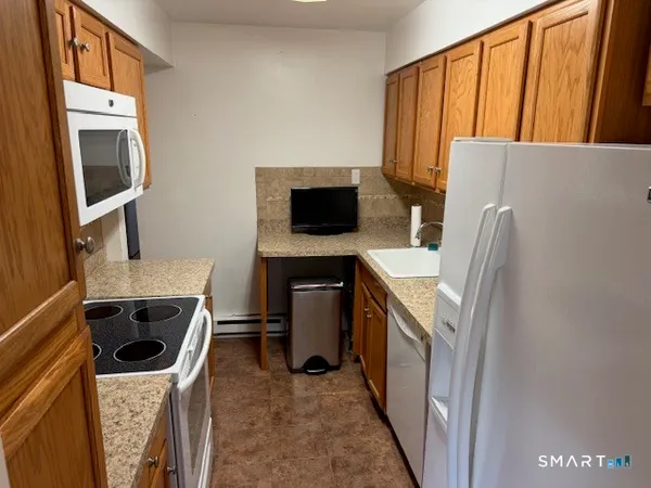 a kitchen with a refrigerator and a stove top oven